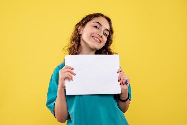 Front view female doctor in medical shirt holding paper analysis, pandemic virus covid-19 uniform emotion