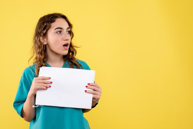 Front view female doctor in medical shirt holding paper analysis, uniform covid-19 pandemic virus emotion