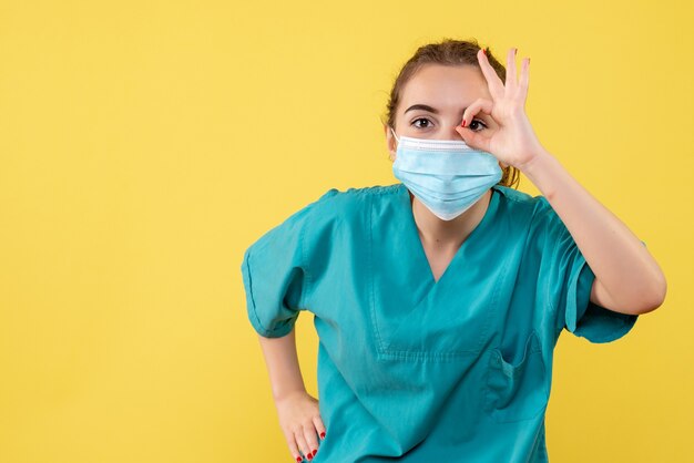 Front view female doctor in medical shirt and mask, color pandemic virus covid-19 uniform