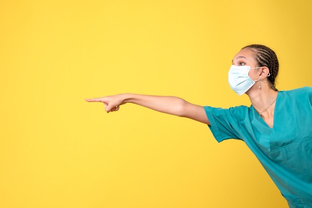 Вид спереди женщина-врач в медицинской рубашке и маске, больница медсестры цвета пандемического вируса covid