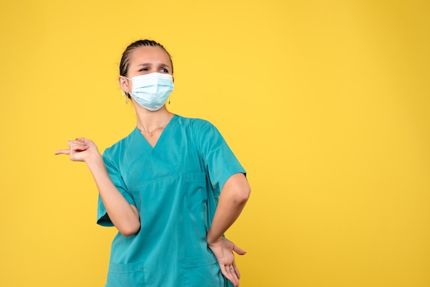 Front view female doctor in medical shirt and mask, virus health nurse hospital covid-19 pandemic color