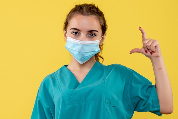 Вид спереди женщина-врач в медицинской рубашке и маске, вирус пандемической формы, цвет здоровья коронавирус covid-19