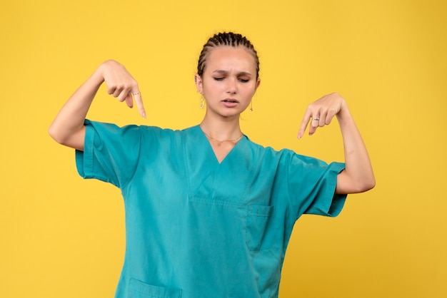 Foto gratuita medico femminile di vista frontale in camicia medica, ospedale dell'infermiera di salute di colore di covid di emozione del medico