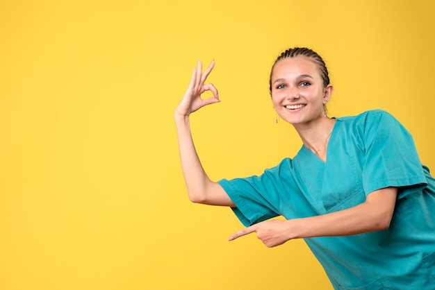 Foto gratuita vista frontale medico donna in camicia medica sorridente, colore salute ospedale emozione infermiera medic covid-