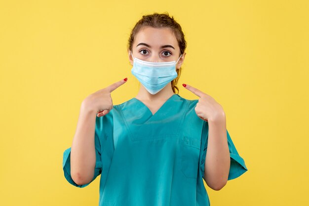 Front view female doctor in medical shirt and sterile mask, coronavirus uniform virus covid-19 pandemic health