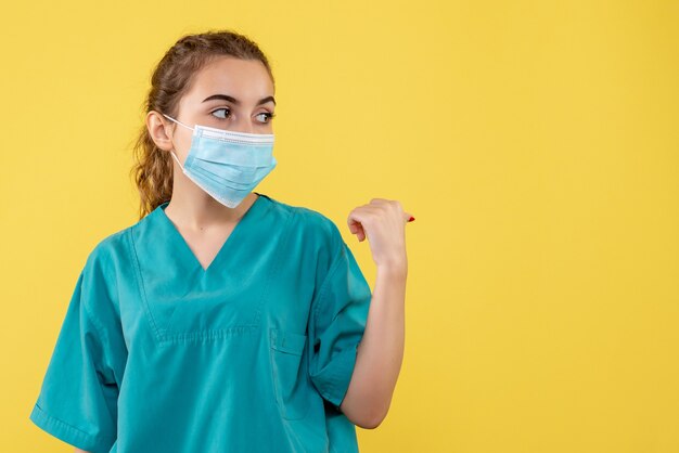 Front view female doctor in medical shirt and sterile mask, illness coronavirus uniform virus covid-19 pandemic health