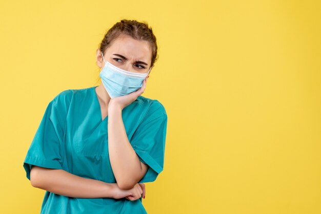 Front view female doctor in medical shirt and sterile mask, illness coronavirus virus covid-19 pandemic health