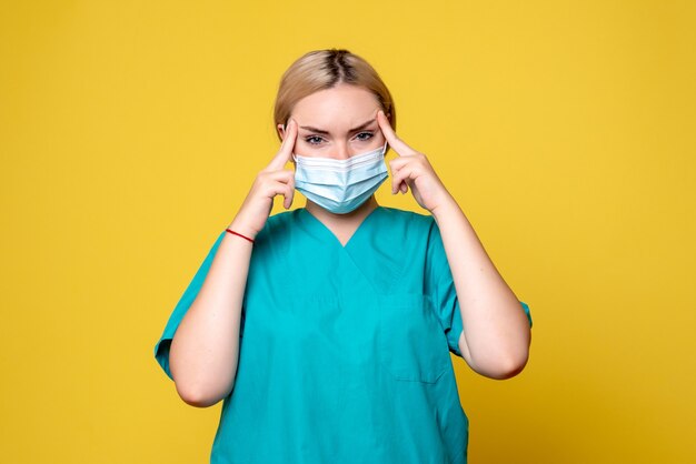 Front view female doctor in medical shirt and sterile mask stressed, hospital covid pandemic health nurse medic