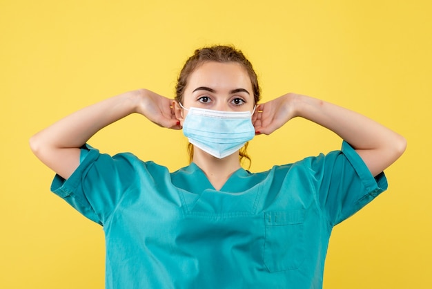 医療シャツと滅菌マスク、ウイルスの均一な色covid-19健康感情の正面図の女性医師
