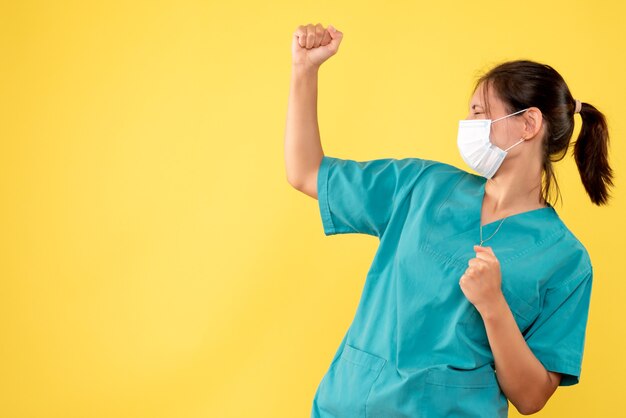 노란색 책상 건강 covid-medic 전염병 병원 바이러스에 의료 셔츠와 멸균 마스크에 전면보기 여성 의사