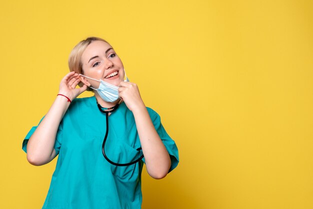 Front view female doctor in medical shirt wearing her mask, nurse medic covid-19 hospital health pandemic