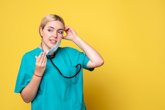 Front view female doctor in medical shirt wearing mask, nurse medic covid-19 hospital health pandemic