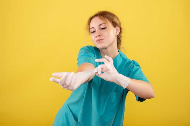 Free photo front view female doctor in medical shirt with gloves, color covid-19 emotion pandemic virus health