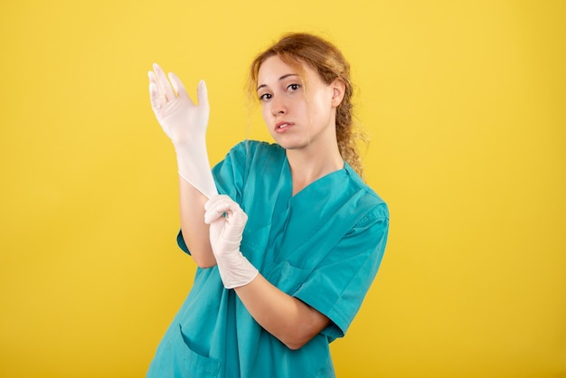 Front view female doctor in medical shirt with gloves, color covid-19 health emotions pandemic virus