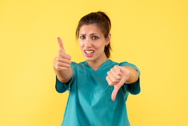 Medico femminile di vista frontale in camicia medica su una priorità bassa gialla