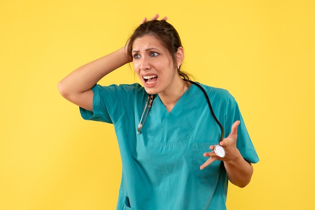 Free photo front view female doctor in medical shirt on yellow background