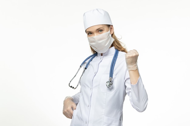 ホワイトデスク病ウイルスのパンデミック病のコロナウイルスによるマスクを身に着けている医療スーツの正面図の女性医師