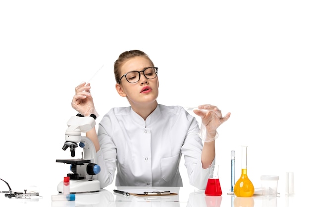 Front view female doctor in medical suit with gloves in working process on white space