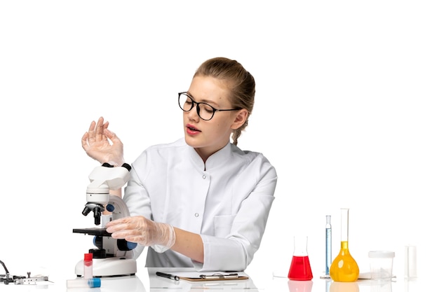 Free photo front view female doctor in medical suit with gloves in working process on white space