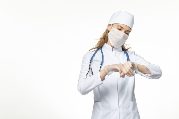 흰색 책상 질병 유행성 covid- 바이러스에 코로나 바이러스로 인해 마스크와 장갑과 의료 소송에서 전면보기 여성 의사