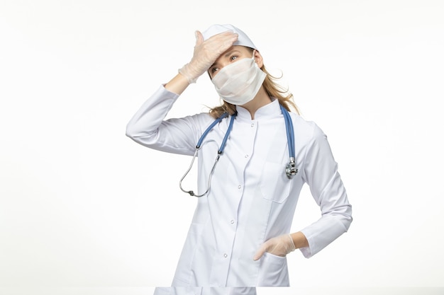 Вид спереди женщина-врач в медицинском костюме с маской и перчатками из-за коронавируса на пандемическом вирусе коронавируса.