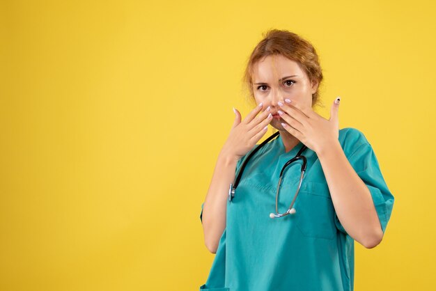 노란색 벽에 청진 기 의료 소송에서 여성 의사의 전면보기