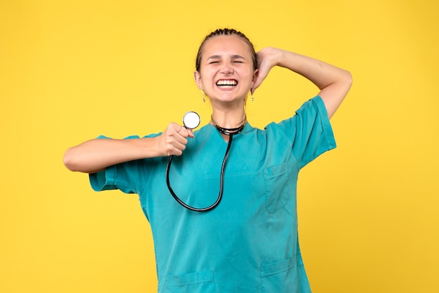 Foto gratuita vista frontale della dottoressa in tuta medica sulla parete gialla