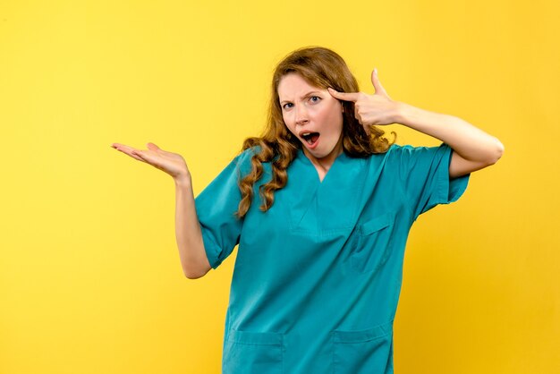 Front view of female doctor nervous on a yellow wall