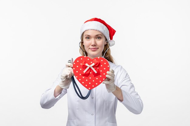 Front view of female doctor observing holiday present on the white wall