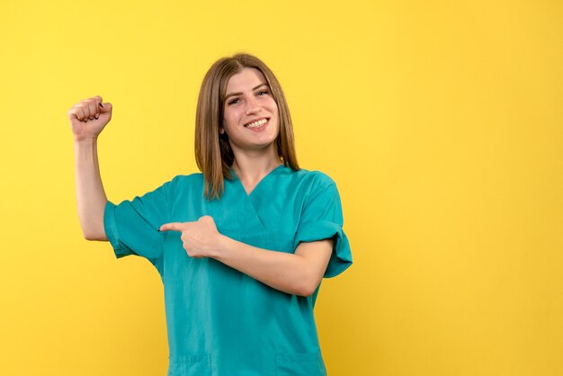 Front view female doctor posing on a yellow space