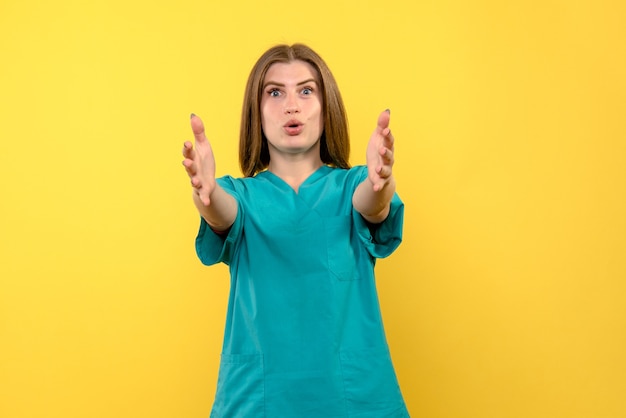 Front view female doctor posing on a yellow space