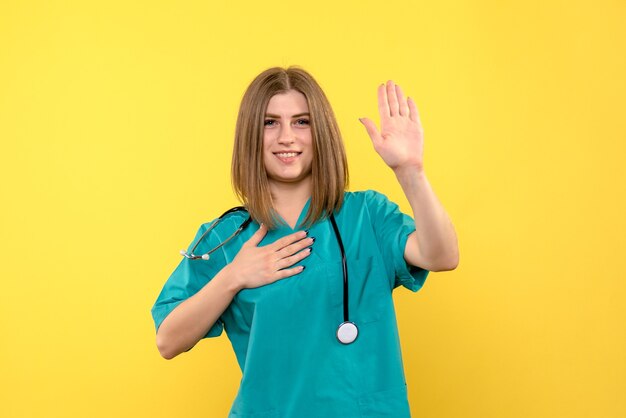 Front view female doctor posing on the yellow space