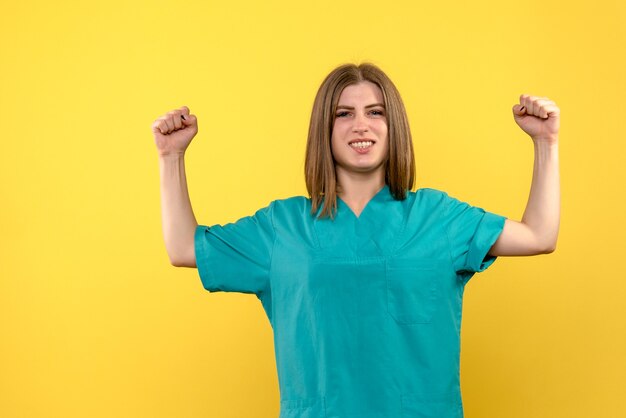 Front view female doctor posing on yellow space