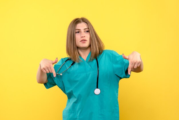 Front view female doctor posing on yellow space