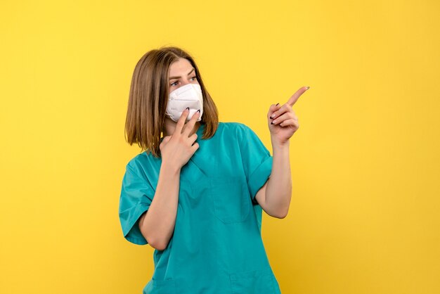 Front view female doctor posing on yellow space