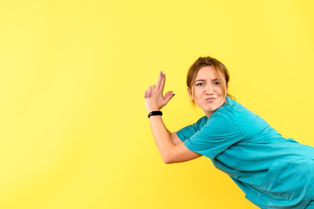 Front view female doctor posing on yellow space