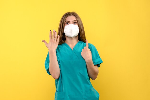 Front view female doctor posing on yellow space