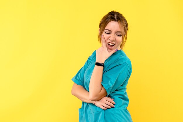 Front view female doctor posing on yellow space