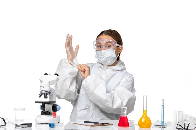 Front view female doctor in protective suit and mask wearing gloves on white background virus covid- health pandemic