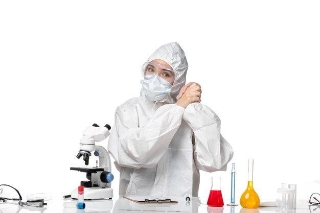 Front view female doctor in protective suit with mask due to covid on a white background virus pandemic splash covid-