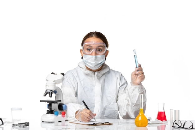 전면보기 여성 의사 보호 복 및 마스크 솔루션 플라스크를 들고 흰색 배경에 쓰기 covid- pandemic coronavirus virus