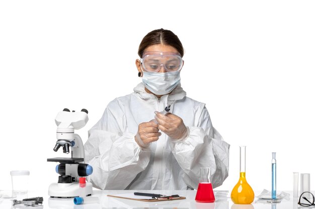 보호 복과 밝은 흰색 배경에 주사로 작업하는 마스크로 전면보기 여성 의사 바이러스 의학 covid pandemic