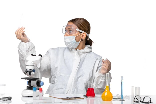 보호 복과 밝은 흰색 배경에 솔루션을 사용하는 마스크로 전면보기 여성 의사 covid virus pandemic coronavirus