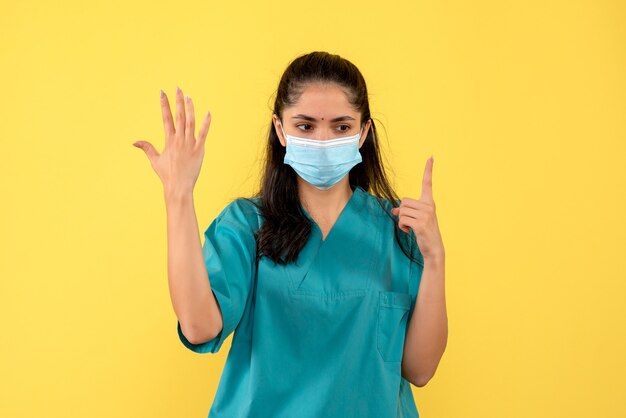 Front view female doctor raising hand pointing at ceiling