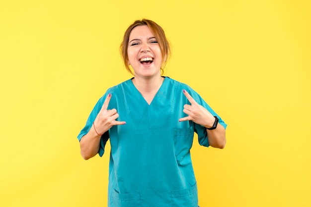 Front view female doctor rejoicing on a yellow space