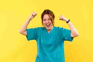 Free photo front view female doctor rejoicing on yellow space