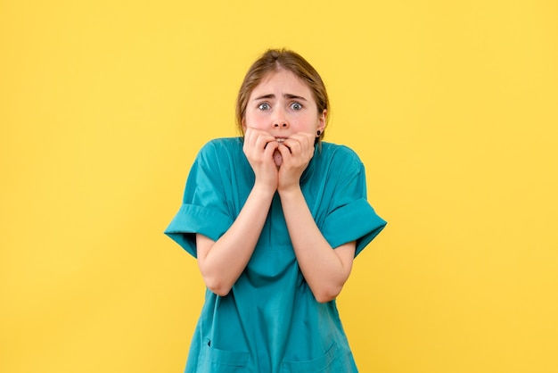 Vista frontale medico femminile spaventato su sfondo giallo salute medico ospedale emozione