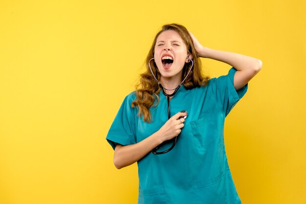 Front view of female doctor screaming on yellow wall