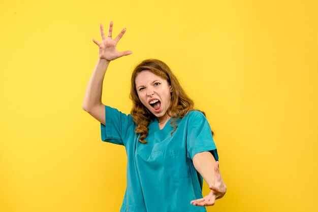 Front view of female doctor screaming on yellow wall