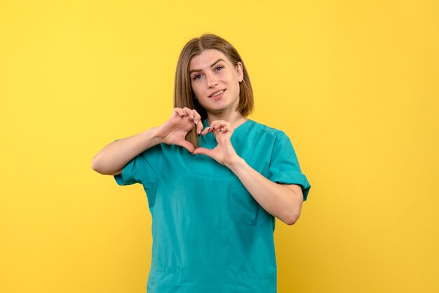 Front view female doctor sending love on yellow space